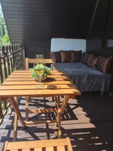 a wooden table with a wine glass and a couch at Chata Leonard in Farná