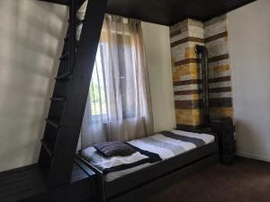 a bed in a room with a window at Chata Leonard in Farná