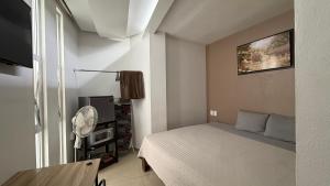 a small bedroom with a bed and a fan at ESPACiOS RAYON in Morelia