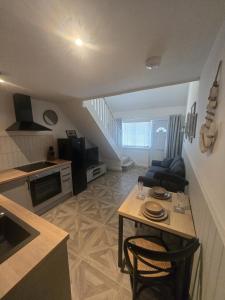 a small living room with a table and a kitchen at Cosy Moat House Cottage #2 in Pembroke