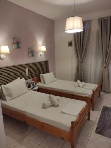 a room with two beds and a lamp at Alisaxni Studios in Pefki