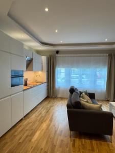 a living room with a couch and a kitchen at Maramaa Backyard Bliss in Viljandi