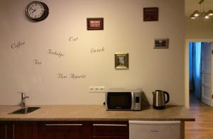 a kitchen counter with a microwave and words on the wall at Orange Cat Rooms in Riga