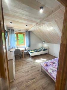 a room with two beds and a desk and a table at Akacjowe Wzgórze in Ruciane-Nida