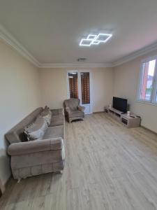 an empty living room with a couch and a tv at Maison de Luxe 2 in Chalon-sur-Saône