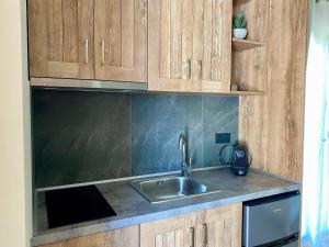 a kitchen with a sink and wooden cabinets at Anogeio in Afitos +47 photos