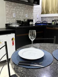 a plate and a wine glass sitting on a table at AP 06 - Apartamento Estudio completo in Balsas