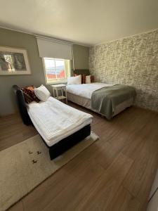 ein Schlafzimmer mit zwei Betten und einem Fenster in der Unterkunft Lantligt läge nära golfbana in Västerås