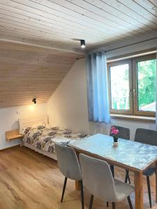 a bedroom with a bed and a table and chairs at Akacjowe Wzgórze in Ruciane-Nida