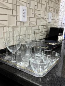 a tray of wine glasses sitting on a counter at AP 06 - Apartamento Estudio completo in Balsas +6 photos