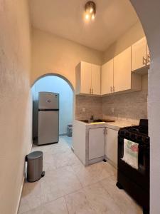 a kitchen with an arched doorway and a refrigerator at Casa Chu in Acapulco