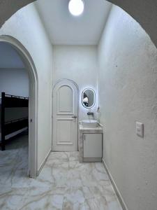 a hallway with a white door and a sink at Casa Chu in Acapulco