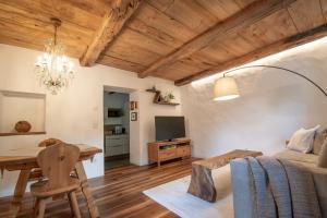 ein Wohnzimmer mit Bett und Tisch sowie ein Esszimmer in der Unterkunft Saxöler Brixen in Brixen