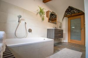 ein Badezimmer mit Badewanne und Dusche in der Unterkunft Saxöler Brixen in Brixen + 17 Fotos