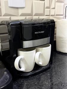 a coffee maker with two cups on top of it at AP 06 - Apartamento Estudio completo in Balsas