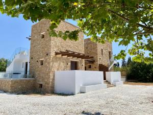 a brick building with white furniture in front of it at Anogeio in Afitos