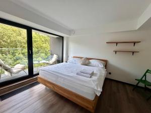 a bedroom with a bed and a large window at Apartmán podlesí in Havířov