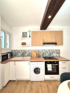 a kitchen with white cabinets and a dishwasher at Maison des Arches in Barbentane
