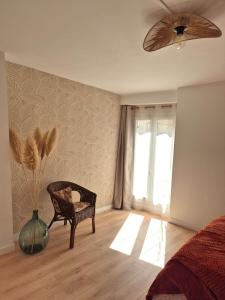 a bedroom with a ceiling fan and a chair and a window at Maison des Arches in Barbentane +10 photos