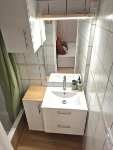 a small bathroom with a sink and a mirror at Maison des Arches in Barbentane