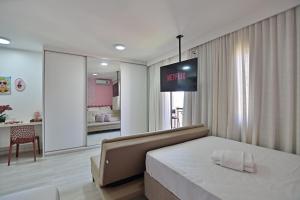 a bedroom with a bed and a tv on the wall at Flat 337 vista lago no Lake side in Brasília +45 photos