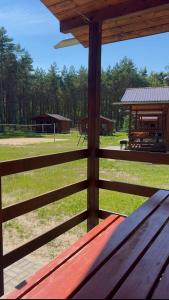 a wooden fence with a picnic table in a park at Domki Letniskowe Morena in Ostrowo