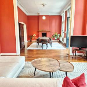 a living room with a couch and a table at Spacious manor house with pool & playground in Essen