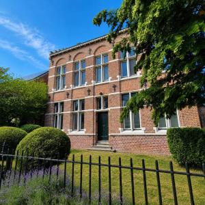 a brick building with a fence in front of it at Spacious manor house with pool & playground in Essen +40 photos