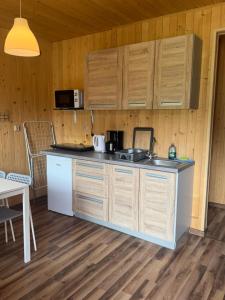 a kitchen with wooden cabinets and a counter top at Domki Letniskowe Morena in Ostrowo