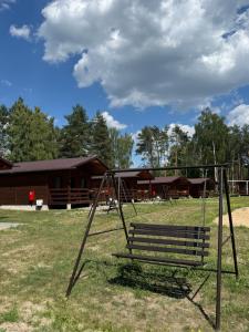 a swing set in a park with a building at Domki Letniskowe Morena in Ostrowo