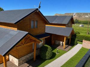 a wooden house with solar panels on its roof at Illihue - Cabañas, Hostería & Spa in Junín de los Andes