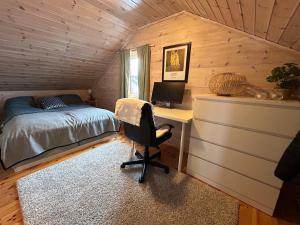 a bedroom with a bed and a desk with a computer at Lyngbu på Stavtjørn in Vikeså
