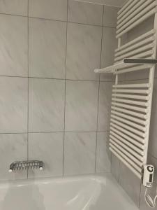 a white bathroom with a tub and a towel rack at Wohnung am Heimberg in Churwalden +54 photos