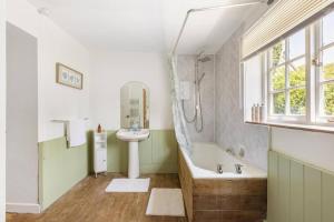 a bathroom with a sink and a bath tub and a sinkessment at Beamed Cottage in Broadwindsor, Wood Burner in Broadwindsor