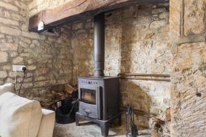 a stone wall with a stove in a room at Beamed Cottage in Broadwindsor, Wood Burner in Broadwindsor