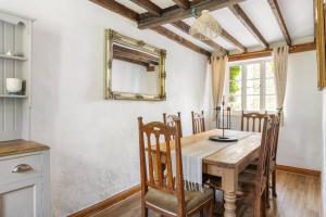 a dining room with a wooden table and chairs at Beamed Cottage in Broadwindsor, Wood Burner in Broadwindsor
