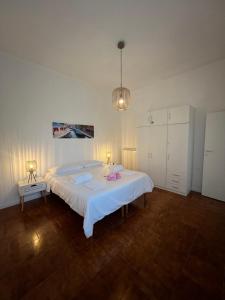 a bedroom with a large white bed and a lamp at Appartamento Sole in Tessera +1 photo