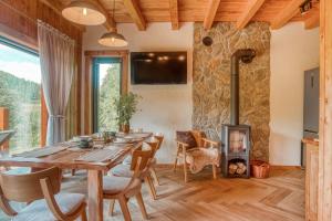 a dining room with a table and a wood stove at Chata Rosocha domek na wyłączność in Cisna