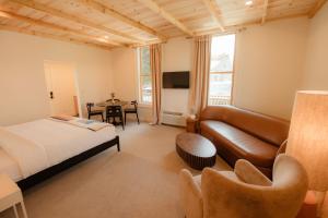 a bedroom with a bed and a couch and a table at The Mill House in Bayfield