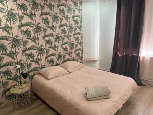 a bedroom with a bed with a palm wallpaper at Gîte du silo Avoine in Toucy