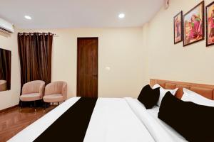 a hotel room with a bed and two chairs at Hotel O Grand Shivay in Indore