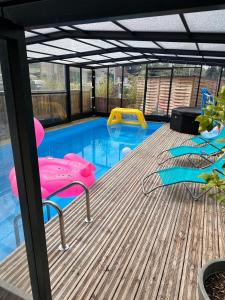 a deck with a pool with two chairs and a slide at Gîte du silo Avoine in Toucy