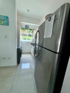 a kitchen with a stainless steel refrigerator in a room at Tepuy Residential in Juan Dolio