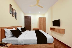 a bedroom with a large bed and a television at Hotel O Grand Shivay in Indore
