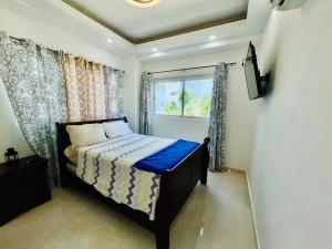 a bedroom with a bed and a window at Tepuy Residential in Juan Dolio