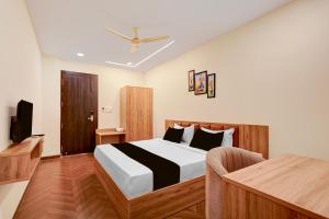 a bedroom with a bed and a television in it at Hotel O Grand Shivay in Indore
