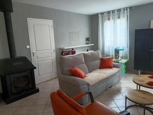 a living room with a couch and a wood stove at Charmante maison avec jacuzzi privatif in Saint-Salvadour