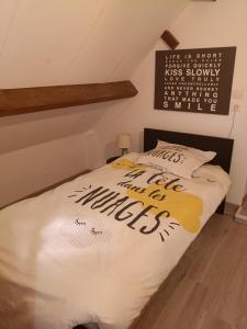 a bed in a room with a sign on the wall at Charmante maison avec jacuzzi privatif in Saint-Salvadour