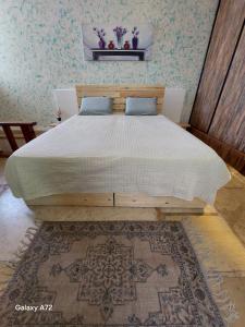 a large bed in a bedroom with a rug at The Essence Tzimer in Safed