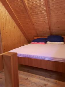 a bed in a wooden room in a cabin at Mariolka Skorzęcin in Skorzęcin +3 photos